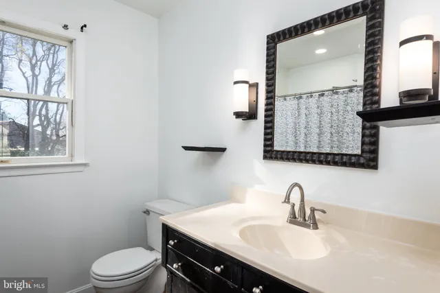 a bathroom with a sink a toilet and mirror