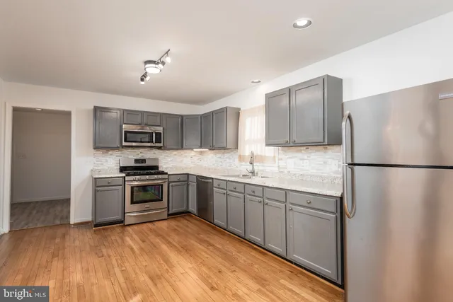 a kitchen with stainless steel appliances granite countertop a refrigerator stove top oven and sink