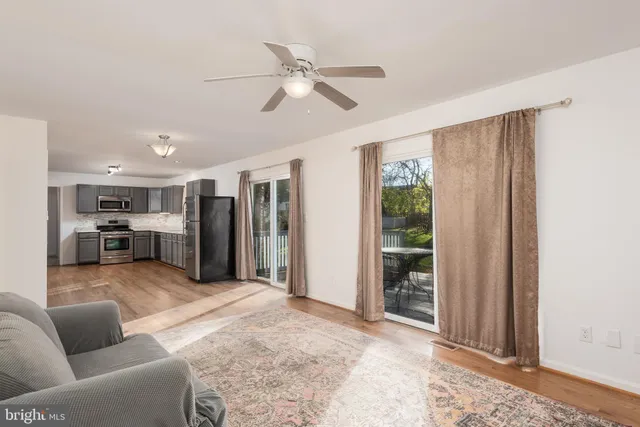 a living room with furniture a ceiling fan and a window