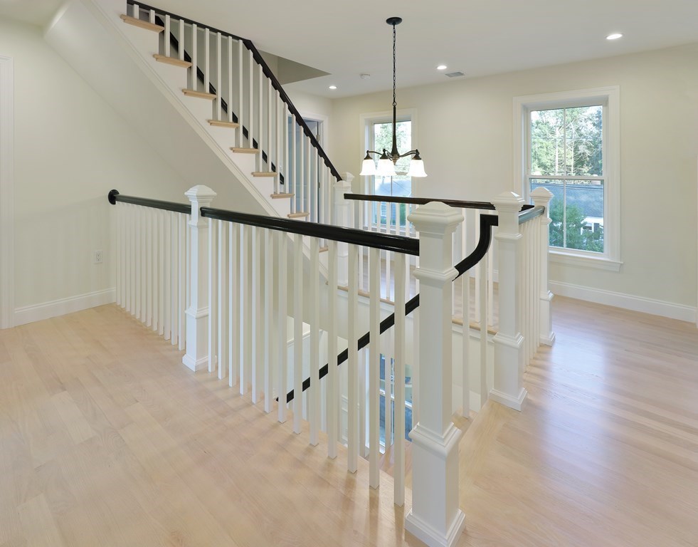 134 Spiers Road Newton, MA 02459 - Photo 20 of 38 a view of staircase and kitchen with wooden floor and pendant lights