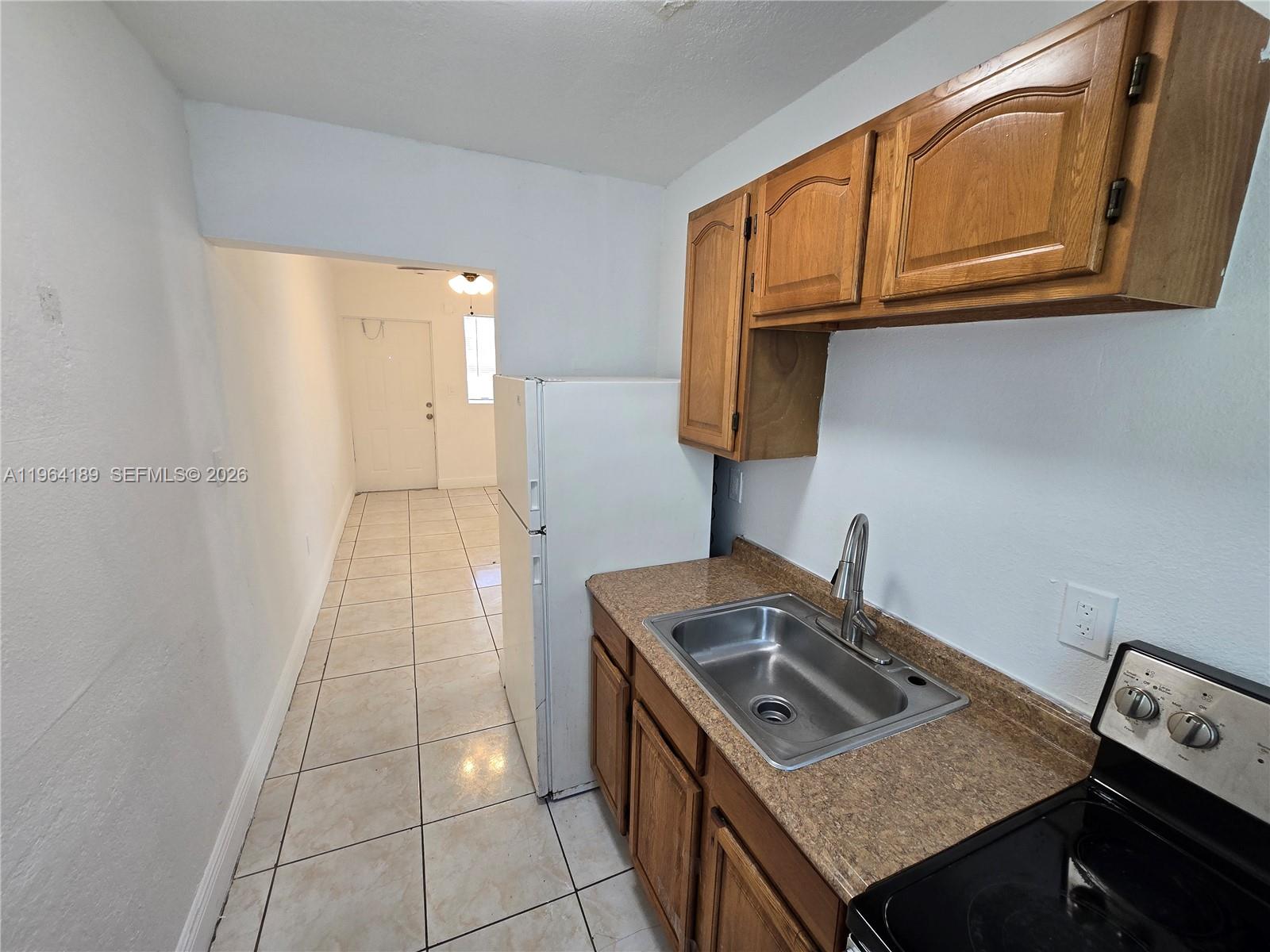 535 Northwest 7th Street, Unit 9 Miami, FL 33136 - Photo 2 of 22 a kitchen with stainless steel appliances granite countertop a stove a sink and a microwave