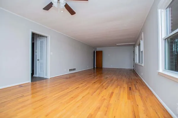 a view of an empty room with wooden floor