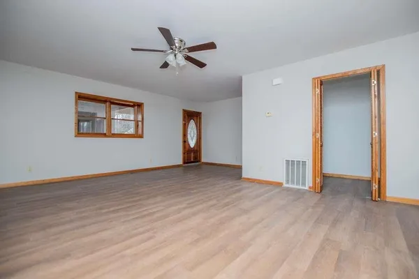 a view of an empty room with wooden floor