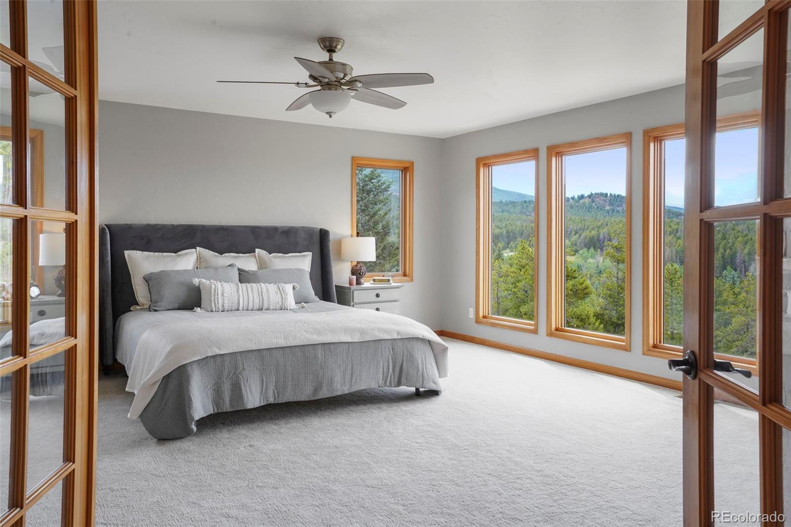 29549 Thunderbolt Circle Conifer, CO 80433 - Photo 15 of 50 a spacious bedroom with a large bed and a large window