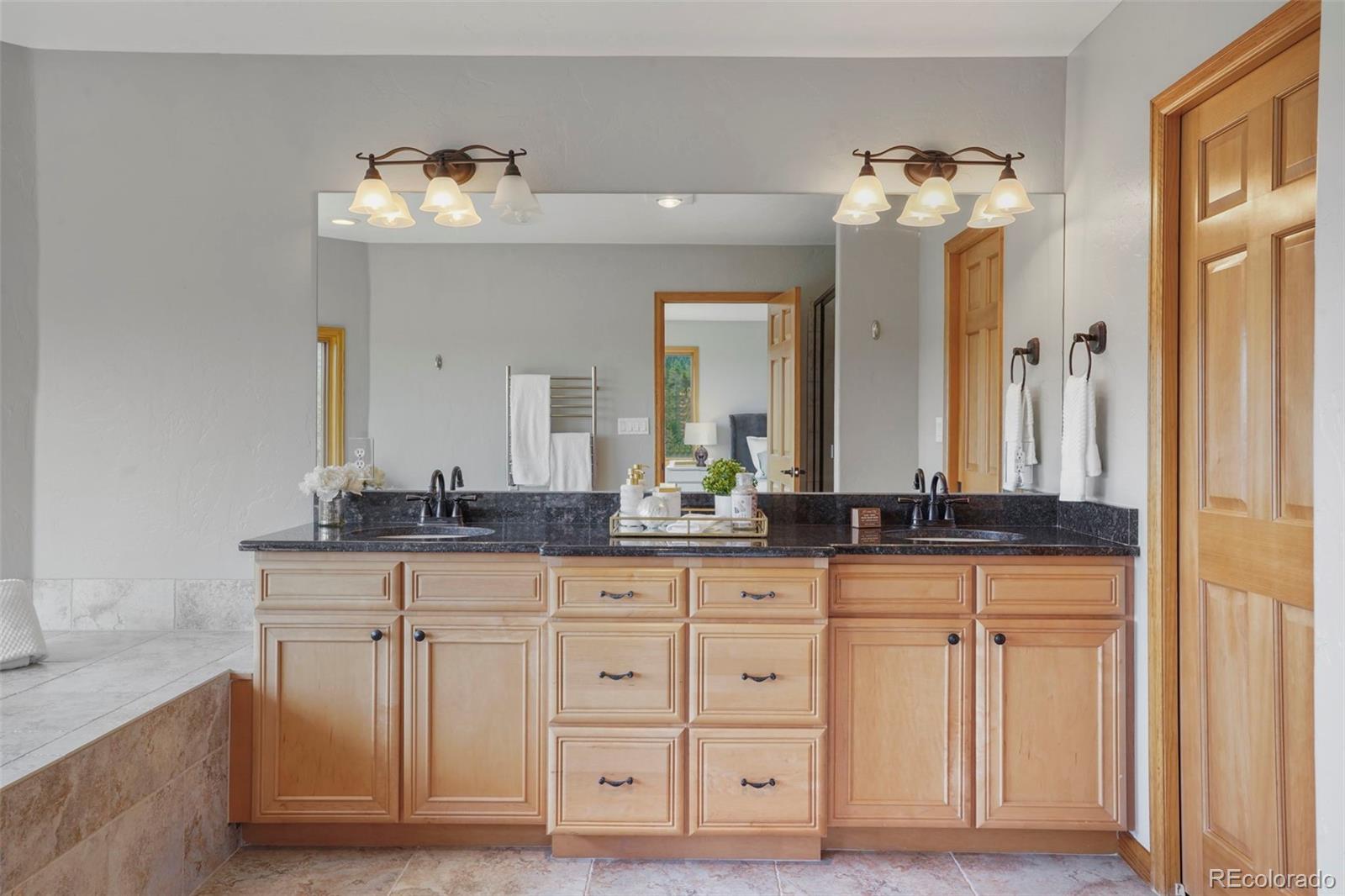29549 Thunderbolt Circle Conifer, CO 80433 - Photo 18 of 50 a bathroom with granite countertop a sink and a mirror