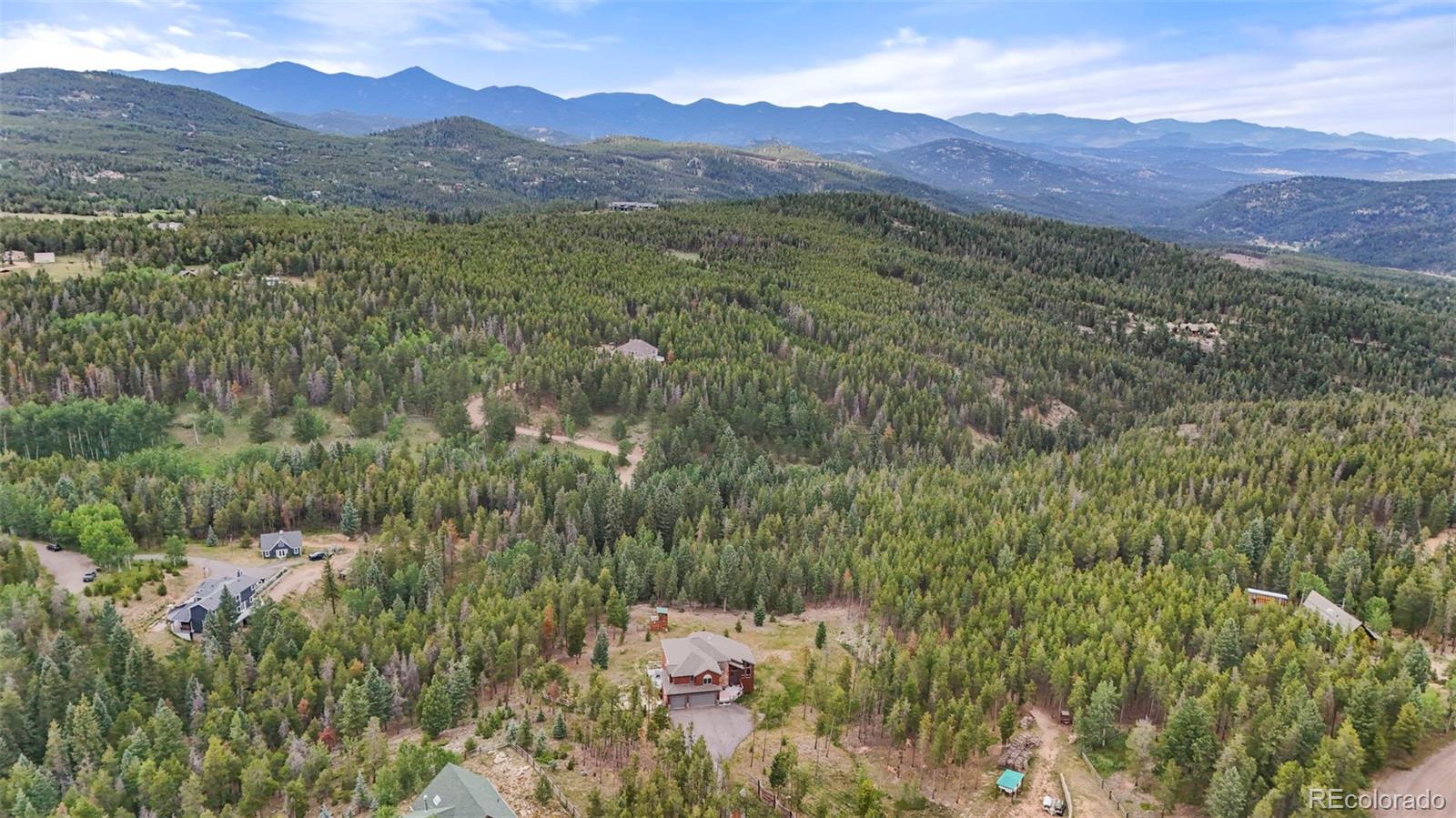 29549 Thunderbolt Circle Conifer, CO 80433 - Photo 46 of 50 a view of a lush green hillside and a houses