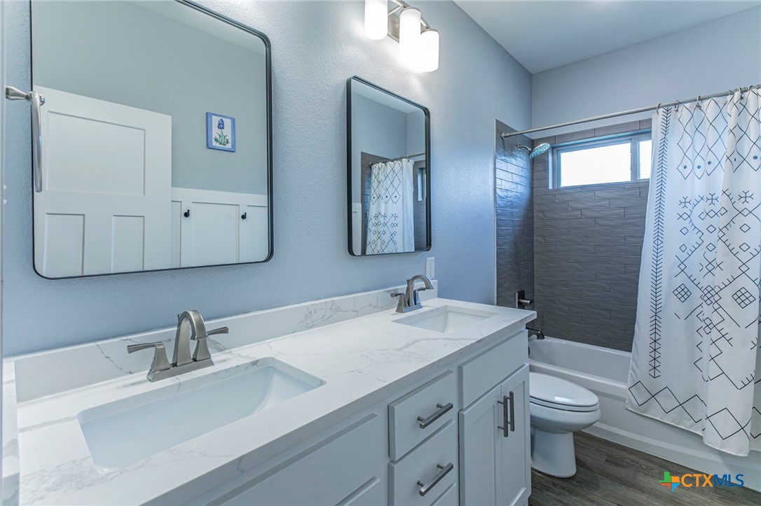 8 Daingerfield Cove Morgan's Point Resort, TX 76513 - Photo 22 of 28 a bathroom with a double vanity sink toilet and shower