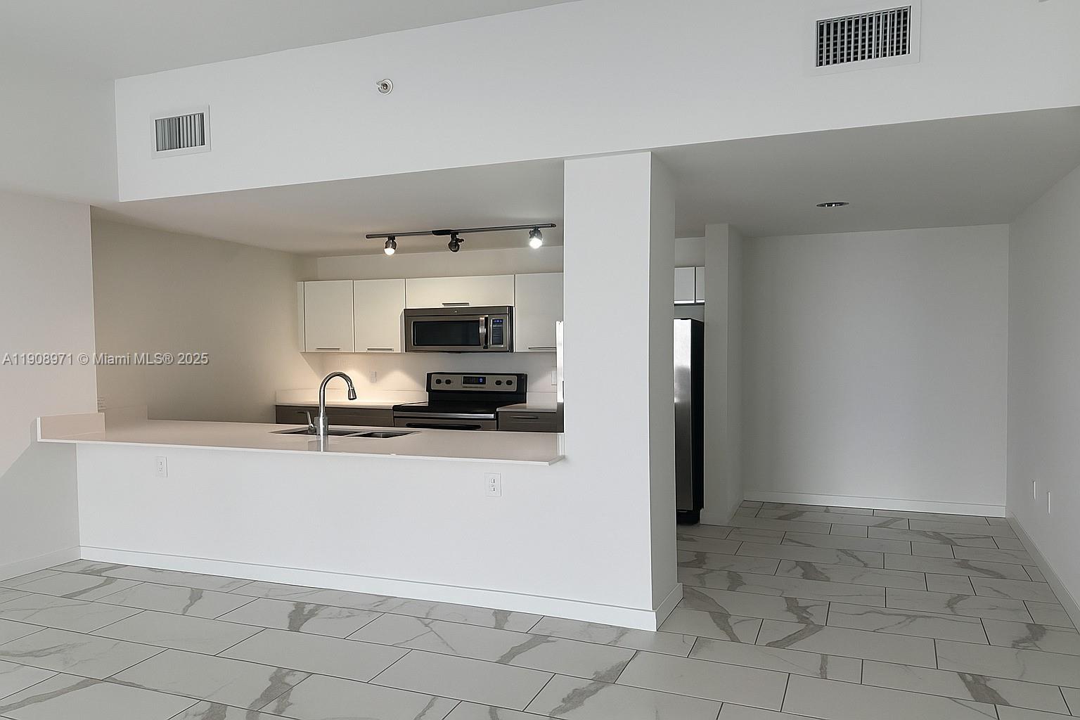 a kitchen with granite countertop a refrigerator and a sink