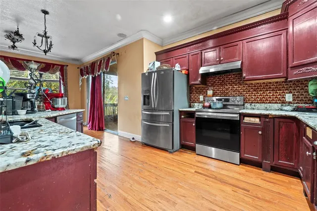 a kitchen with stainless steel appliances granite countertop a refrigerator stove and sink