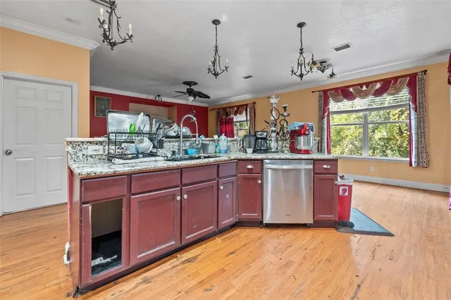 a kitchen with stainless steel appliances granite countertop a stove a sink dishwasher and a wooden cabinets