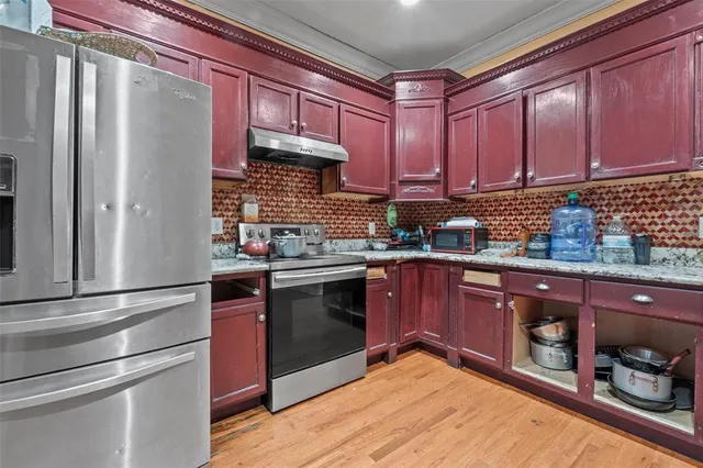 a kitchen with stainless steel appliances granite countertop a refrigerator and a stove top oven