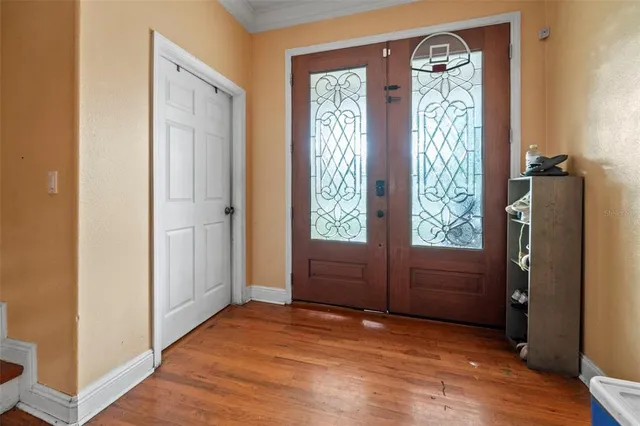 a view of an empty room with a window and wooden floor