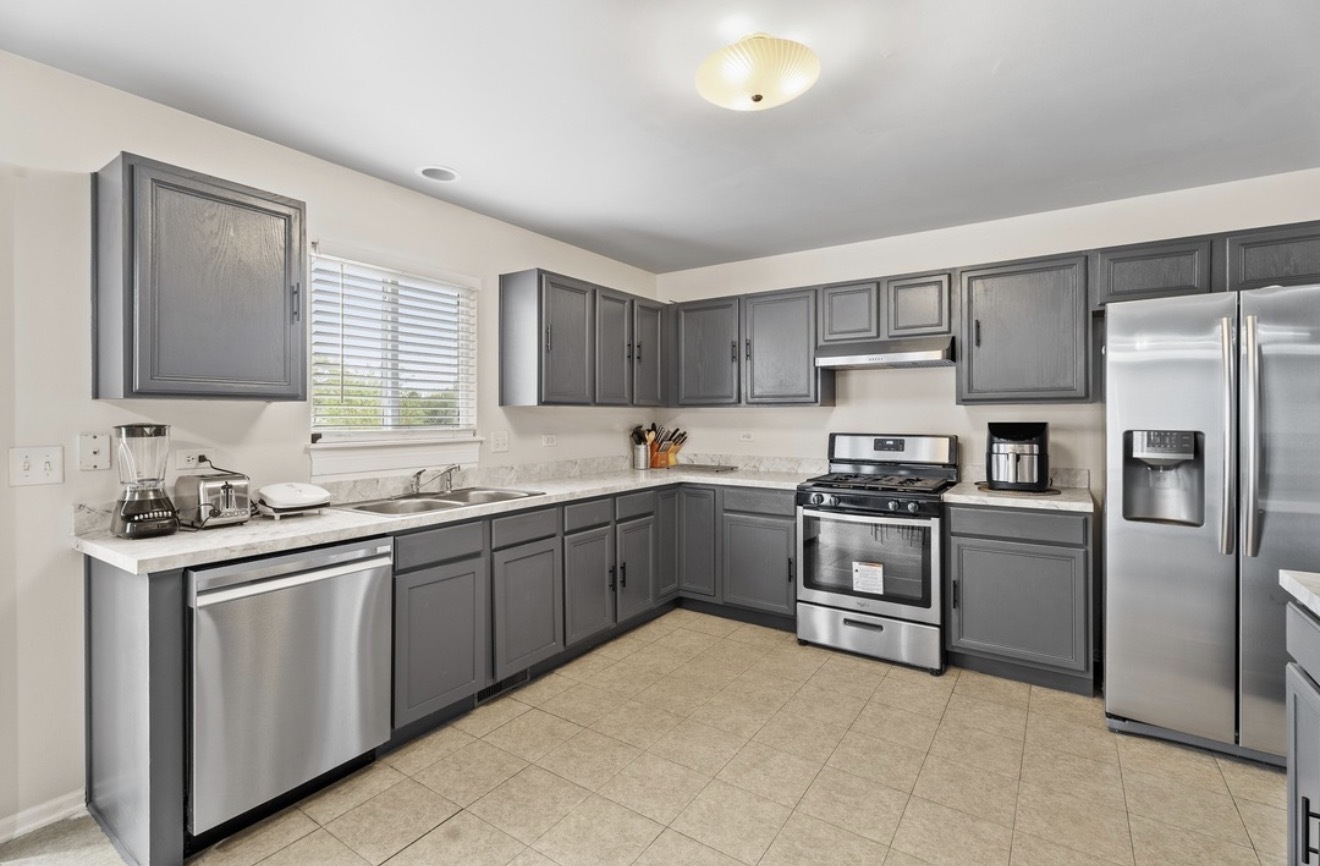 412 Clifton Lane Bolingbrook, IL 60440 - Photo 2 of 12 a kitchen with stainless steel appliances granite countertop a stove top oven a sink dishwasher a refrigerator and cabinets with wooden floor