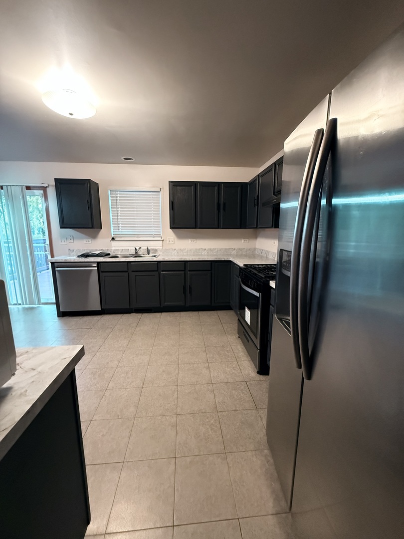 412 Clifton Lane Bolingbrook, IL 60440 - Photo 3 of 12 a kitchen with stainless steel appliances a microwave sink and cabinets