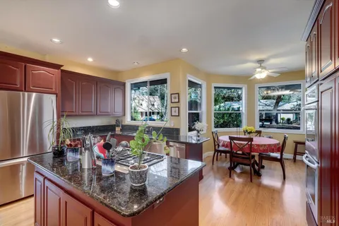 a living room with furniture large windows and wooden floor