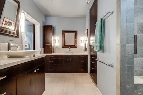 a spacious bathroom with a double vanity sink a mirror and a shower