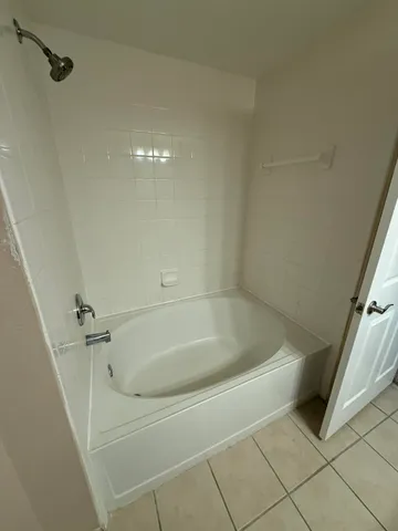 a bath tub sitting next to a white marble wall