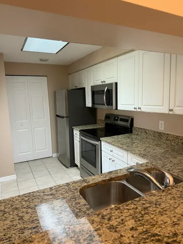 a kitchen with a sink cabinets and stainless steel appliances