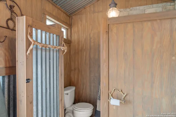 a bathroom with a toilet a sink and shower curtain
