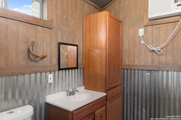 a bathroom with a sink a light fixture and a mirror