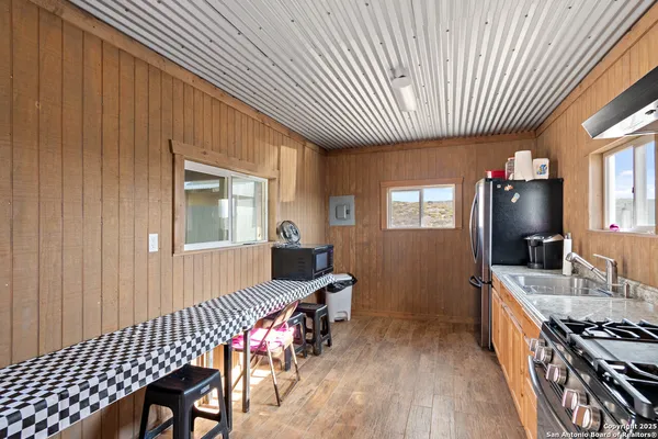 a kitchen with stainless steel appliances granite countertop a stove a sink dishwasher and a refrigerator with wooden floor