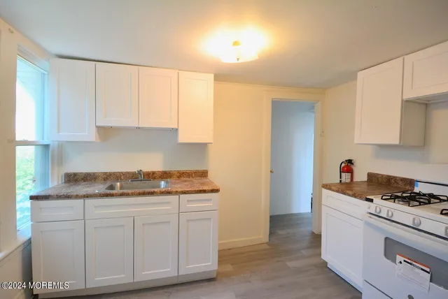 a kitchen with white cabinets and white appliances