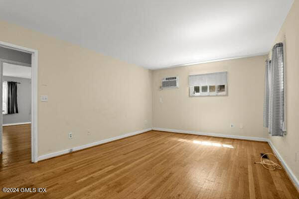 21 Hycliff Road, Unit COTTAGE Greenwich, CT 06831 - Photo 4 of 7 an empty room with wooden floor and windows