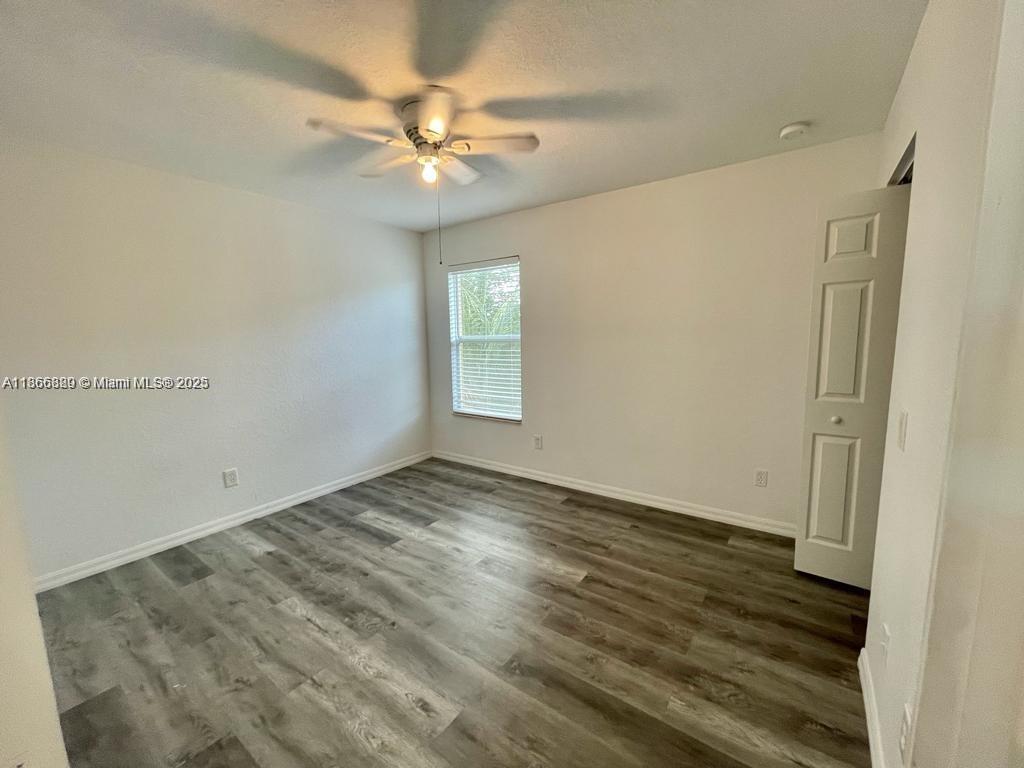 804 Quartz Terrace West Palm Beach, FL 33413 - Photo 13 of 15 an empty room with wooden floor and fan