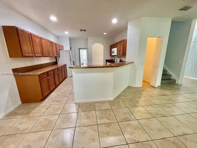 a kitchen with stainless steel appliances a sink a microwave a stove a refrigerator and cabinets