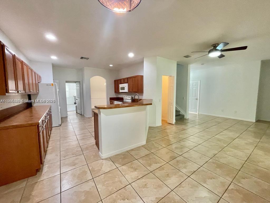 804 Quartz Terrace West Palm Beach, FL 33413 - Photo 6 of 15 a kitchen with stainless steel appliances kitchen island granite countertop a refrigerator and a stove top oven