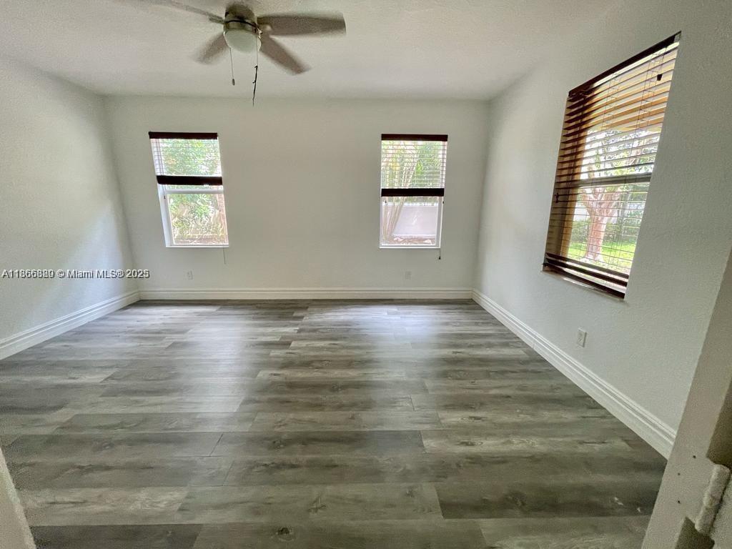 804 Quartz Terrace West Palm Beach, FL 33413 - Photo 9 of 15 a view of an empty room with a window and wooden floor