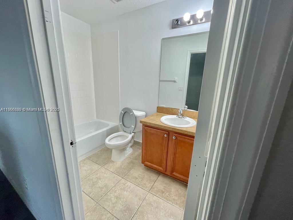 804 Quartz Terrace West Palm Beach, FL 33413 - Photo 10 of 15 a bathroom with a granite countertop sink toilet and shower