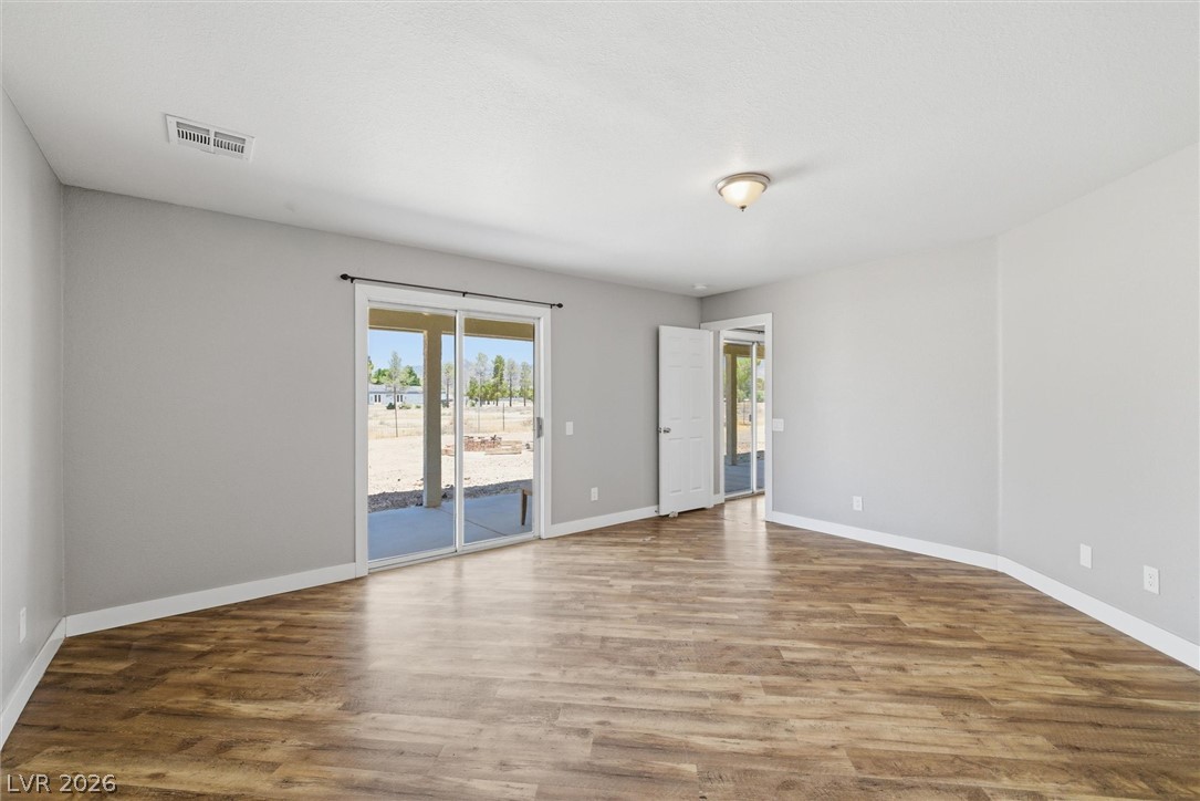 2780 West Simkins Road Pahrump, NV 89060 - Photo 24 of 40 Sliding glass doors open onto a private patio, extending the living area outdoors.