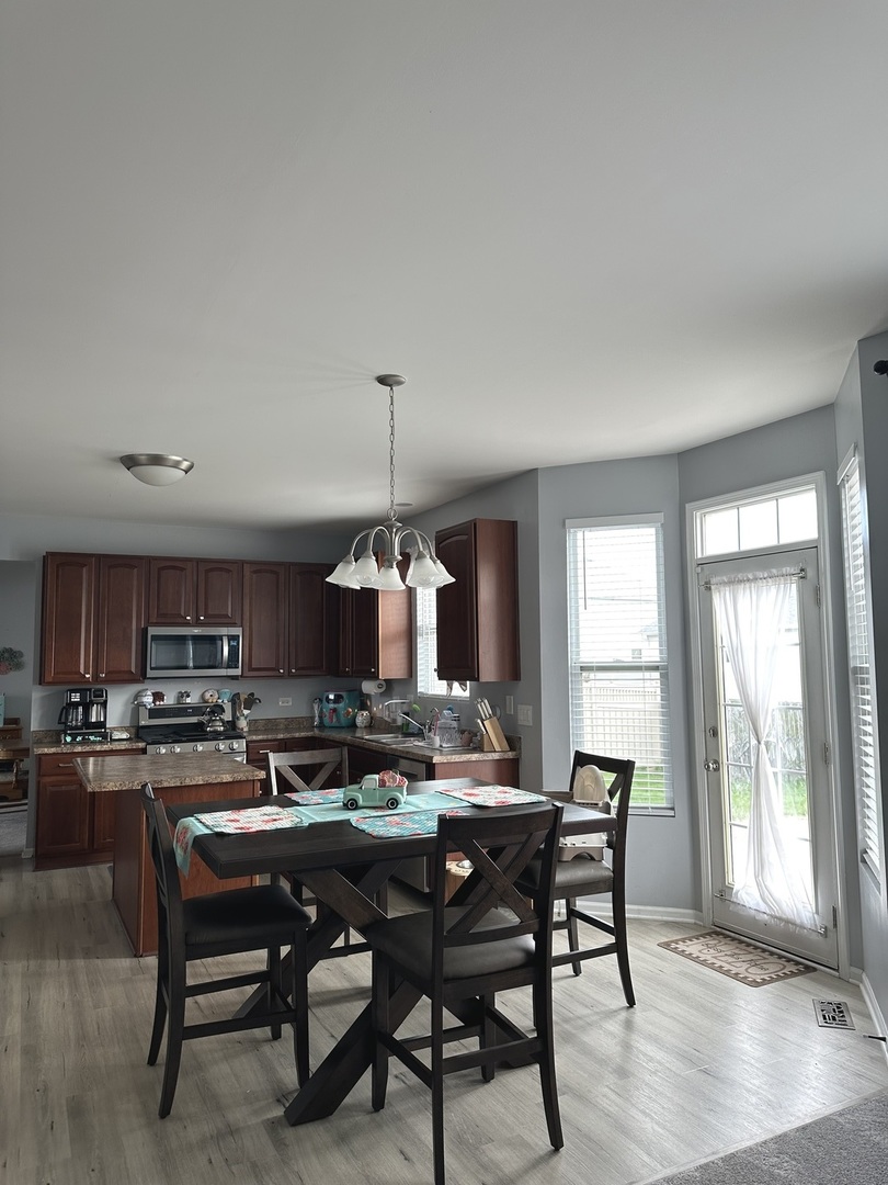 571 Wynbrooke Road Romeoville, IL 60446 - Photo 3 of 15 a view of a dining room with furniture window and wooden floor