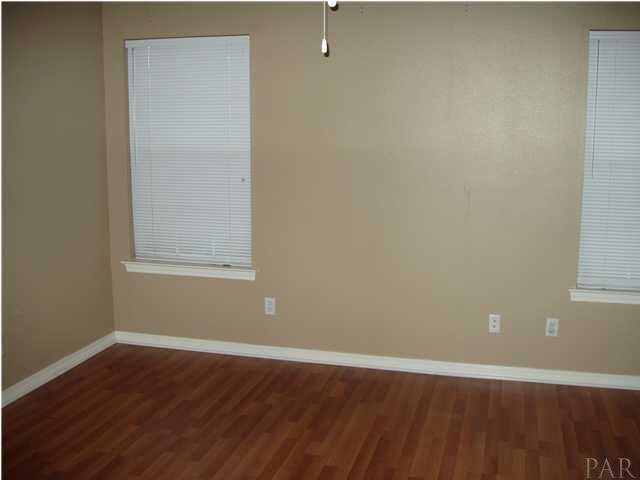 The Master Bedroom with its rich colored laminate wood flooring and its neutral paint scheme.