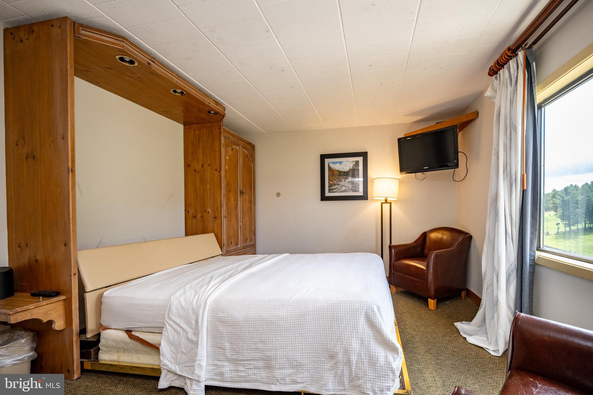 290 Marsh Hill Road, Unit 702K McHenry, MD 21541 - Photo 15 of 45 a bedroom with a bed chair and a window