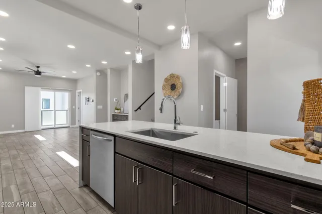 a kitchen with stainless steel appliances granite countertop a sink a stove and a wooden floors