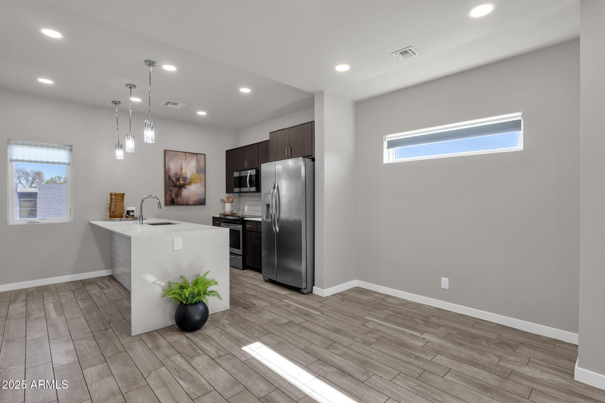 2727 East Thomas Road, Unit 9 Phoenix, AZ 85016 - Photo 9 of 46 a kitchen with stainless steel appliances a refrigerator sink and wooden floor