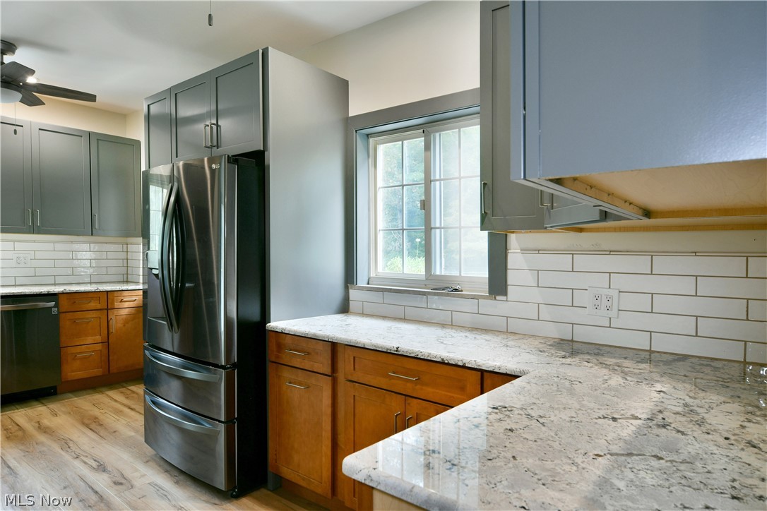 892 Yankee Run Road Masury, OH 44438 - Photo 19 of 50 Modern kitchen featuring stainless steel appliances, granite countertops, white subway tile backsplash, wood-finish flooring, and gray cabinetry