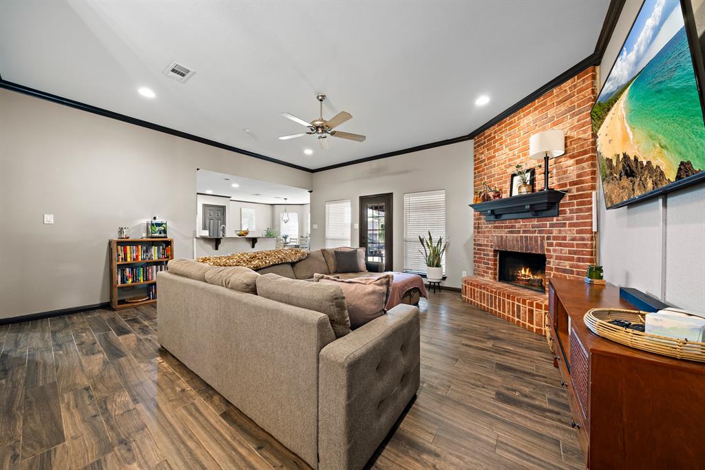 10512 Whitney Trace Drive Waco, TX 76708 - Photo 21 of 39 Living area featuring wood-finish flooring, a brick fireplace with a dark mantel, and recessed lighting