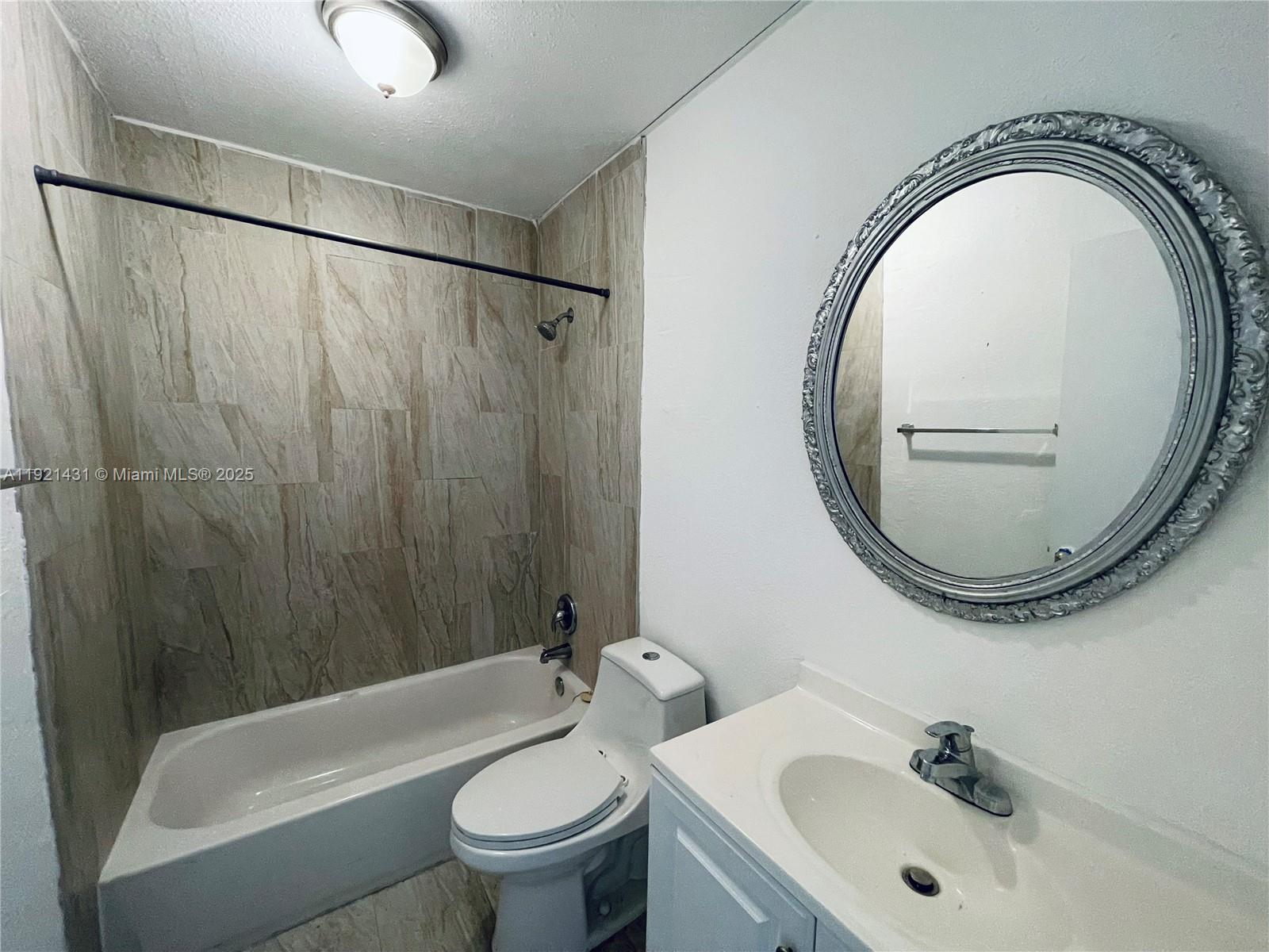 825 Northwest 46th Avenue, Unit 825 Plantation, FL 33317 - Photo 7 of 12 a bathroom with a sink a toilet and a mirror