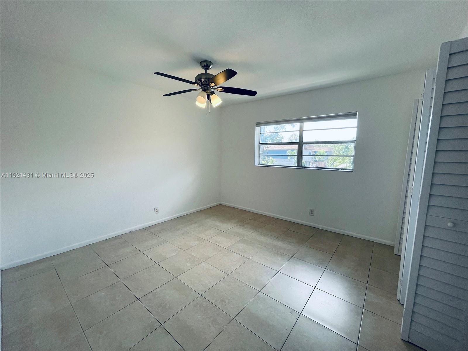 825 Northwest 46th Avenue, Unit 825 Plantation, FL 33317 - Photo 9 of 12 an empty room with windows and fan