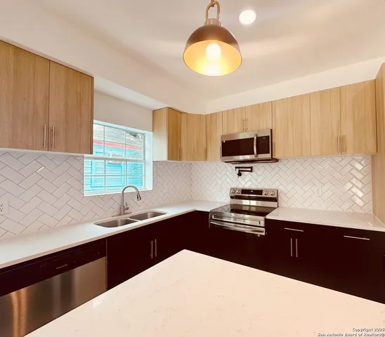 a kitchen with a sink a stove and microwave