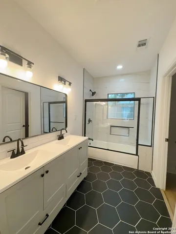 a bathroom with a double vanity sink mirror and