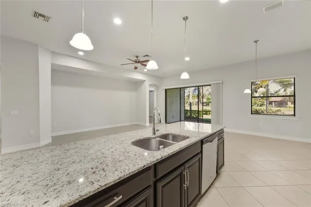 a view of a kitchen with kitchen island stainless steel appliances refrigerator sink and cabinets