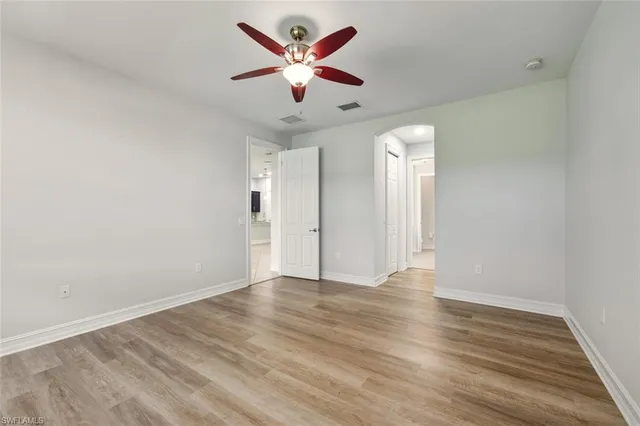 a view of an empty room with a chandelier fan