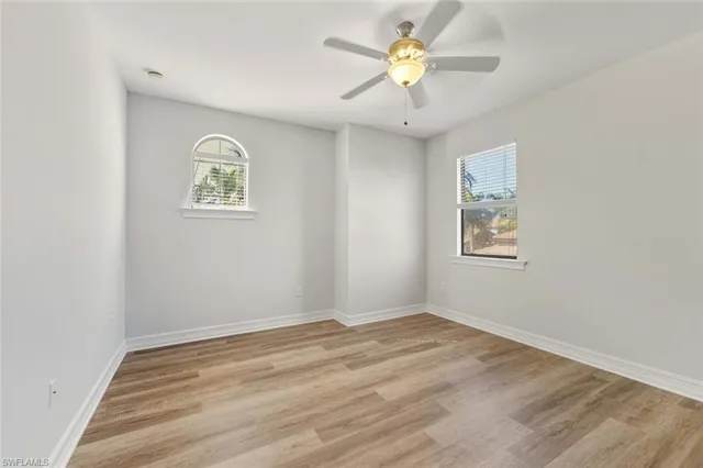 a view of a big room with wooden floor and windows