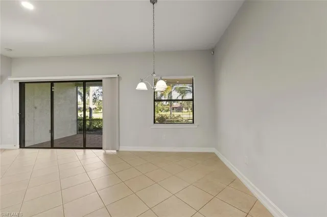 a large kitchen with stainless steel appliances a large counter top and a refrigerator