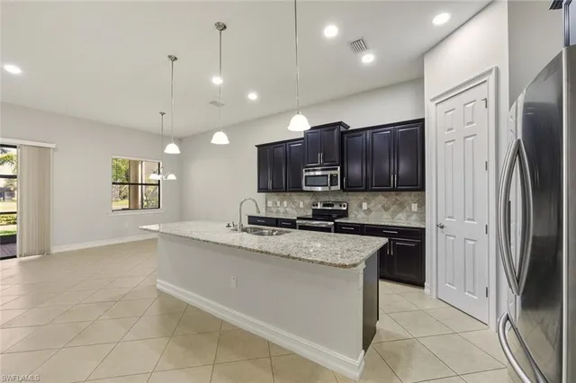 a large kitchen with kitchen island granite countertop a large counter top and stainless steel appliances