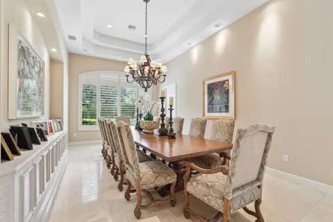 a view of a dining room with furniture a chandelier and wooden floor